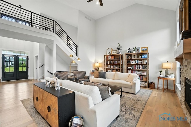 4214 Thornbury Ct, Perrysburg, OH 43551 - living area featuring a stone fireplace, high vaulted ceiling, stairway, a ceiling fan, and light wood-style floors