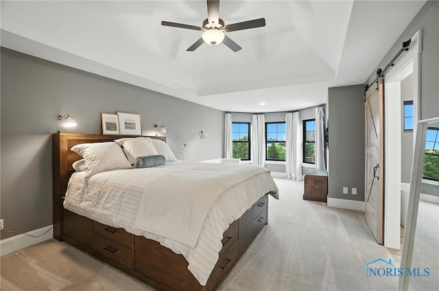 4214 Thornbury Ct, Perrysburg, OH 43551 - bedroom with a barn door, light colored carpet, a tray ceiling, and multiple windows