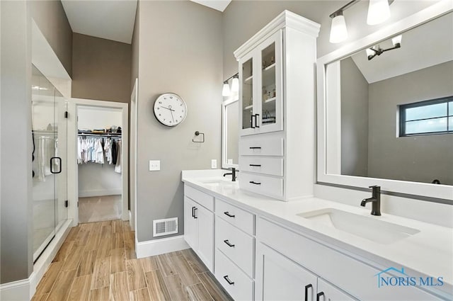4214 Thornbury Ct, Perrysburg, OH 43551 - bathroom with a shower stall, double vanity, a spacious closet, and wood finished floors