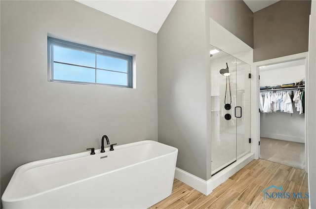 4214 Thornbury Ct, Perrysburg, OH 43551 - bathroom featuring a shower stall, a spacious closet, wood finished floors, a freestanding bath, and lofted ceiling