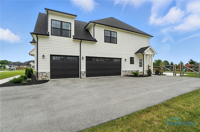 4214 Thornbury Ct, Perrysburg, OH 43551 - view of front of property featuring asphalt driveway, stone siding, an attached garage, and roof with shingles