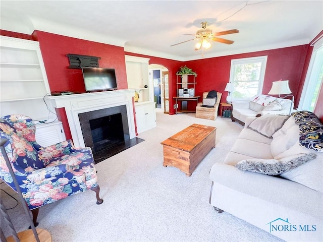 1925 Harlan Rd, Toledo, OH 43615 - living room with ceiling fan, carpet flooring, a fireplace with flush hearth, and arched walkways