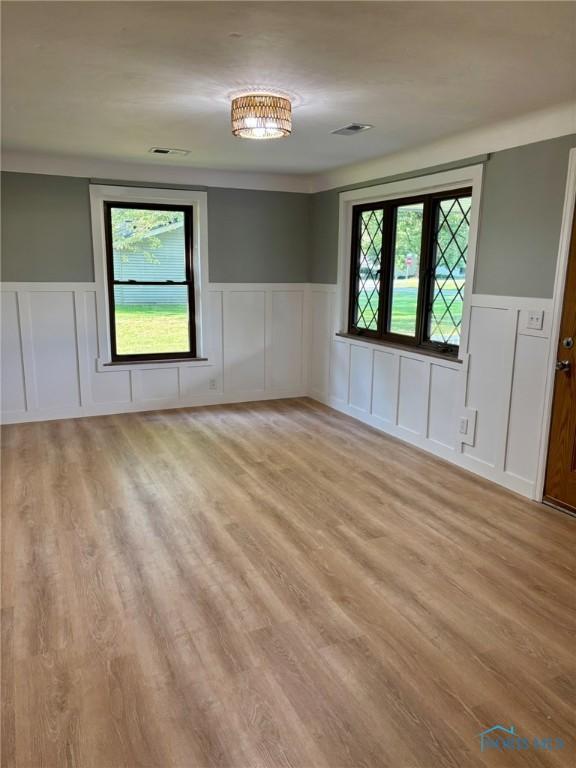 1948 Sudbury Dr, Holland, OH 43528 - unfurnished room featuring a wainscoted wall, light wood-style flooring, and a decorative wall
