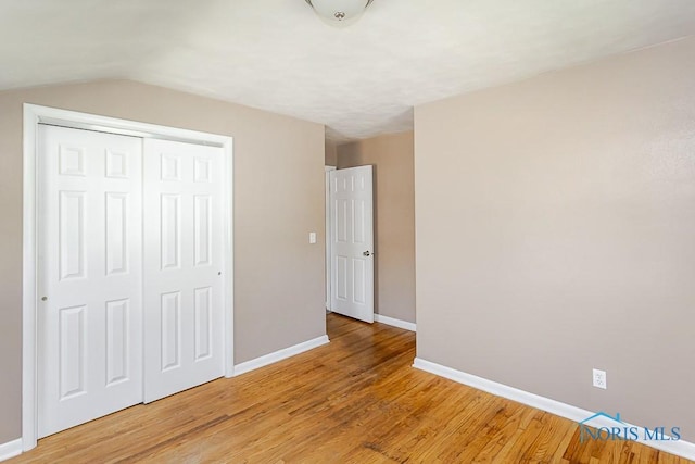 1831 Evansdale Ave, Toledo, OH 43607 - unfurnished bedroom featuring a closet, light wood-style flooring, and lofted ceiling