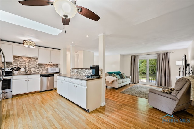 6961 Convent Blvd, Sylvania, OH 43560 - kitchen featuring appliances with stainless steel finishes, open floor plan, a ceiling fan, decorative backsplash, and white cabinetry