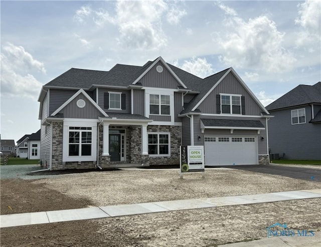 14 Hawthorne Xing, Perrysburg, OH 43551 - craftsman-style home featuring stone siding, board and batten siding, a garage, and driveway