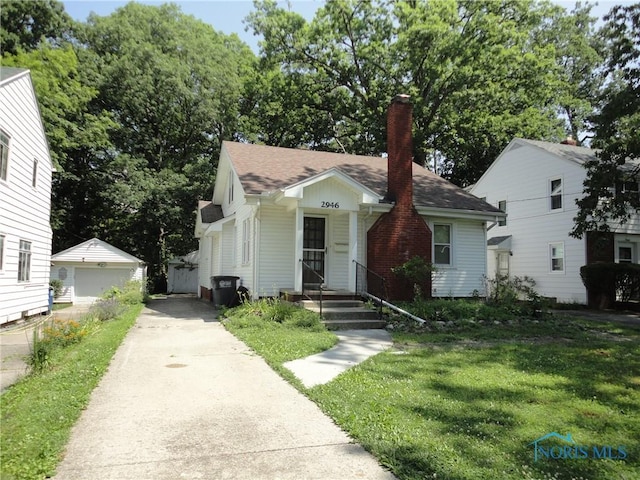 2946 Oxbridge Dr, Toledo, OH 43614 - bungalow-style house featuring a chimney, an outdoor structure, a front lawn, and roof with shingles