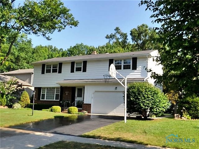 2748 Tarrytowne Dr, Toledo, OH 43613 - traditional-style house featuring brick siding, a garage, a front lawn, and driveway