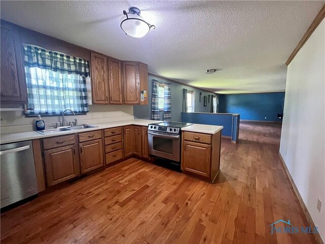 107 N Maple St, Payne, OH 45880 - kitchen featuring appliances with stainless steel finishes, a textured ceiling, wood finished floors, a peninsula, and light countertops