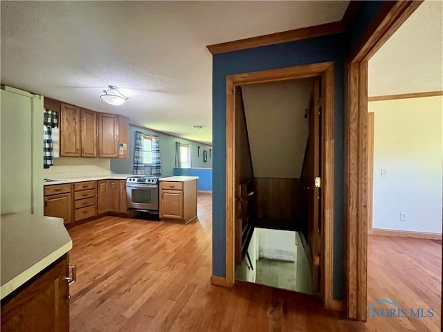 107 N Maple St, Payne, OH 45880 - kitchen with stainless steel range with electric stovetop, light wood-style floors, light countertops, brown cabinetry, and a textured ceiling
