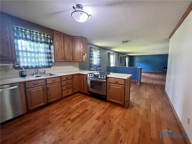 107 N Maple St, Payne, OH 45880 - kitchen featuring appliances with stainless steel finishes, a textured ceiling, wood finished floors, a peninsula, and light countertops