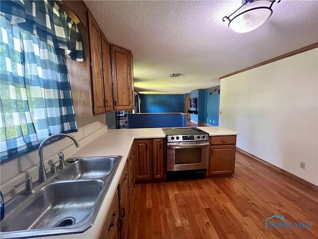 107 N Maple St, Payne, OH 45880 - kitchen with stainless steel range with electric stovetop, brown cabinets, wood-type flooring, a textured ceiling, and light countertops