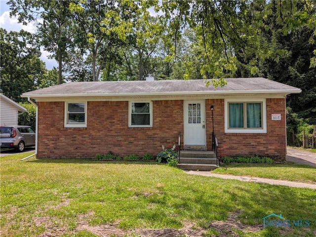 6607 Hill Ave, Toledo, OH 43615 - view of front facade with entry steps, brick siding, and a front lawn