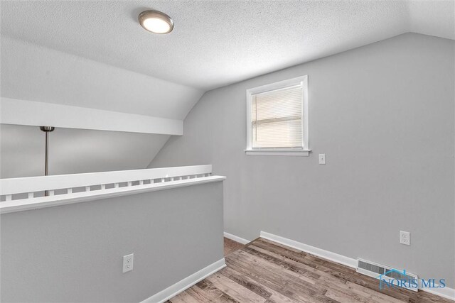 1845 Newport Ave, Toledo, OH 43613 - additional living space featuring lofted ceiling, wood finished floors, and a textured ceiling