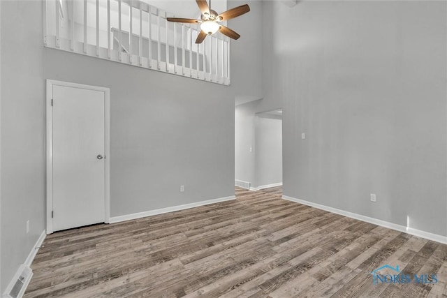 1845 Newport Ave, Toledo, OH 43613 - unfurnished living room with a high ceiling, a ceiling fan, and wood finished floors