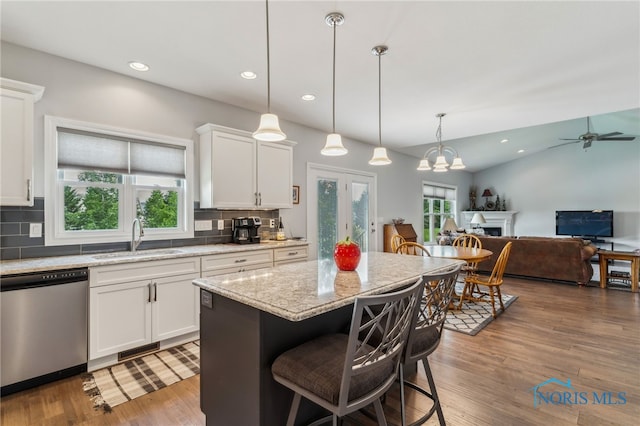 3525 Magnolia Dr, Findlay, OH 45840 - kitchen featuring stainless steel dishwasher, decorative backsplash, white cabinets, a kitchen bar, and recessed lighting
