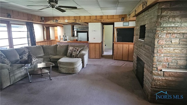 49 N Norden Rd, Oregon, OH 43616 - living area featuring carpet flooring, a stone fireplace, a drop ceiling, and a ceiling fan