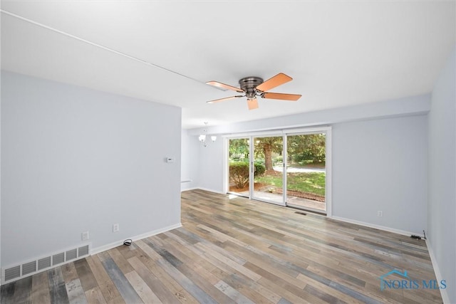 5679 Monroe St Unit 118, Sylvania, OH 43560 - unfurnished room with a ceiling fan, wood finished floors, and a chandelier