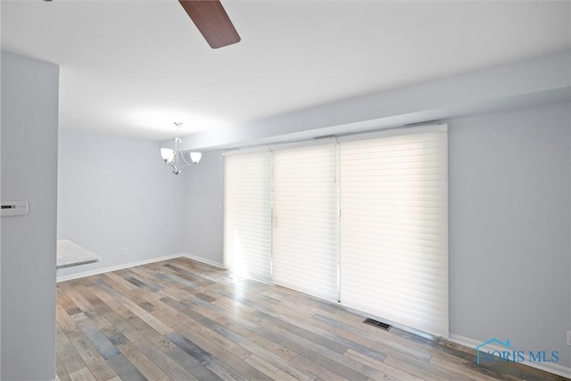 5679 Monroe St Unit 118, Sylvania, OH 43560 - unfurnished room with a chandelier, ceiling fan, and wood-type flooring