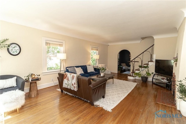 2448 Orchard Rd, Ottawa Hills, OH 43606 - living area featuring arched walkways, wood finished floors, plenty of natural light, and stairway