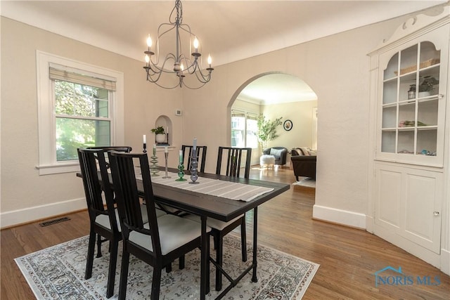 2448 Orchard Rd, Ottawa Hills, OH 43606 - dining space with arched walkways, wood finished floors, and a chandelier