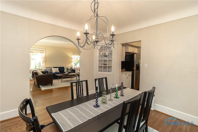 2448 Orchard Rd, Ottawa Hills, OH 43606 - dining area with arched walkways, wood finished floors, and a chandelier