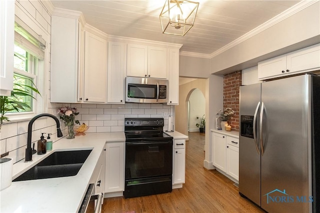 2448 Orchard Rd, Ottawa Hills, OH 43606 - kitchen with stainless steel appliances, arched walkways, decorative backsplash, white cabinetry, and light countertops