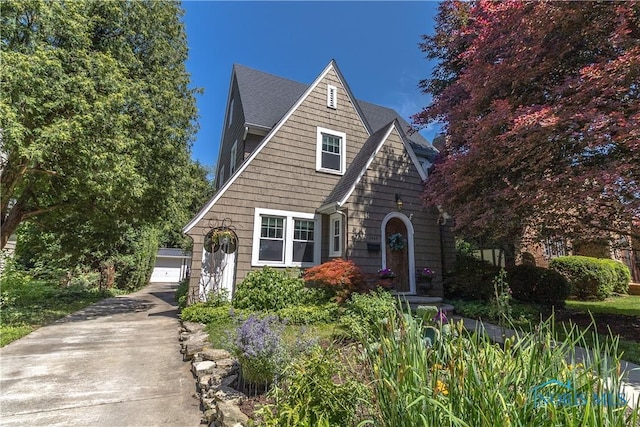 2448 Orchard Rd, Ottawa Hills, OH 43606 - tudor home featuring an outdoor structure, a shingled roof, and a garage
