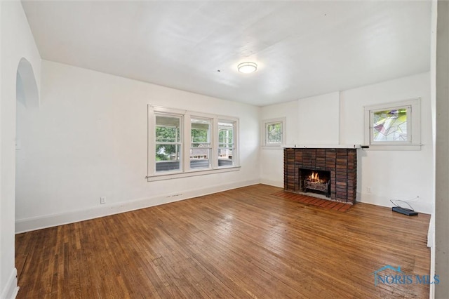 3042 Schneider Rd, Toledo, OH 43614 - unfurnished living room with plenty of natural light, wood-type flooring, a fireplace, and arched walkways