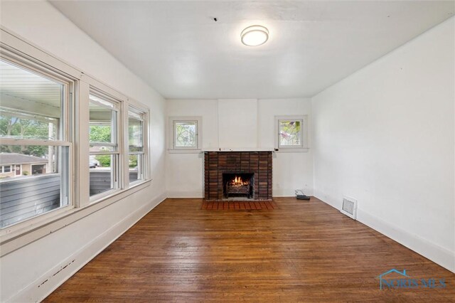 3042 Schneider Rd, Toledo, OH 43614 - unfurnished living room featuring healthy amount of natural light, a fireplace, and wood-type flooring
