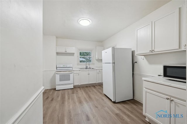 3042 Schneider Rd, Toledo, OH 43614 - kitchen featuring white appliances, white cabinets, light countertops, and light wood finished floors