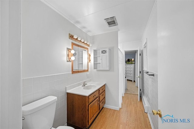 699 N Toussaint S Rd, Oak Harbor, OH 43449 - half bathroom with tile walls, crown molding, vanity, wood finished floors, and a wainscoted wall