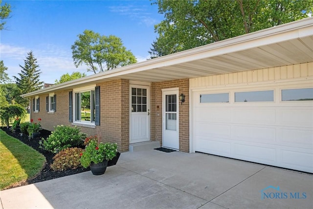 699 N Toussaint S Rd, Oak Harbor, OH 43449 - view of front facade with brick siding, concrete driveway, and a garage