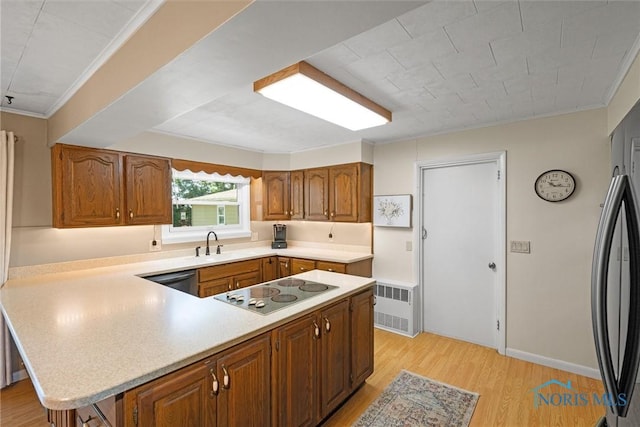 699 N Toussaint S Rd, Oak Harbor, OH 43449 - kitchen featuring electric stovetop, light countertops, light wood finished floors, brown cabinetry, and ornamental molding