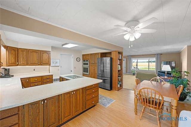 699 N Toussaint S Rd, Oak Harbor, OH 43449 - kitchen featuring appliances with stainless steel finishes, brown cabinetry, a ceiling fan, light wood-type flooring, and crown molding