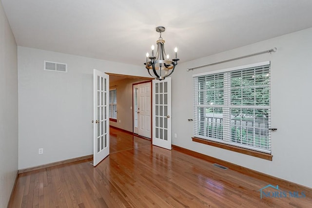 820 Weatherstone Rd, Holland, OH 43528 - empty room featuring french doors, a chandelier, and wood finished floors