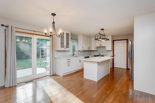 820 Weatherstone Rd, Holland, OH 43528 - kitchen with a chandelier, light wood-style flooring, light countertops, decorative backsplash, and white cabinets