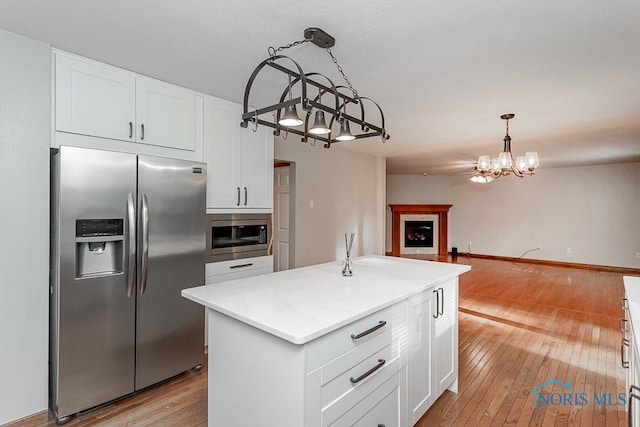 820 Weatherstone Rd, Holland, OH 43528 - kitchen featuring appliances with stainless steel finishes, a chandelier, open floor plan, light wood-style flooring, and white cabinetry