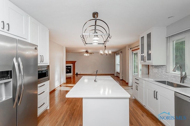 820 Weatherstone Rd, Holland, OH 43528 - kitchen with stainless steel appliances, a center island, light wood-style flooring, and ceiling fan