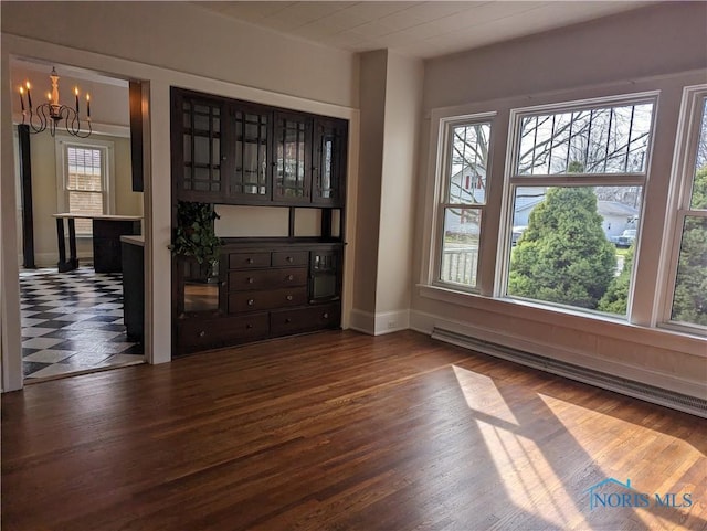 301 E Bigelow St, Upper Sandusky, OH 43351 - spare room featuring a baseboard heating unit, a chandelier, and wood finished floors