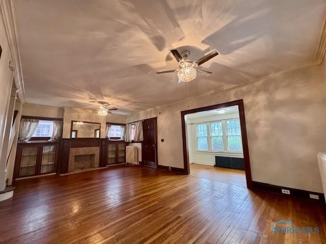 2840 Scottwood Ave, Toledo, OH 43610 - unfurnished living room with radiator heating unit, a ceiling fan, and healthy amount of natural light