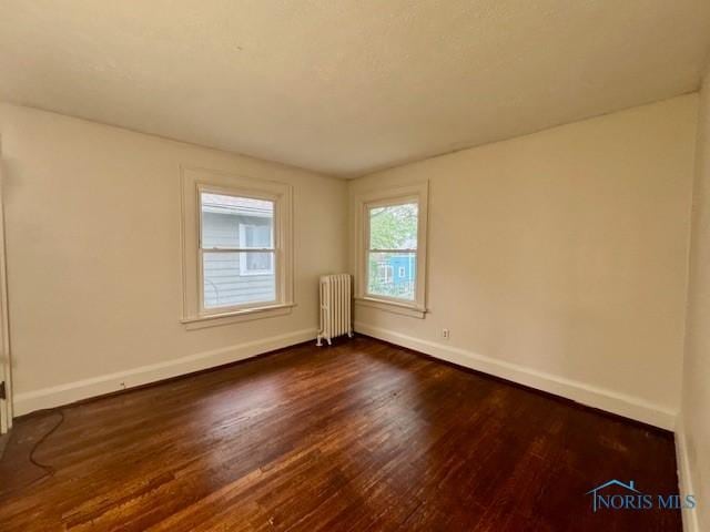 2840 Scottwood Ave, Toledo, OH 43610 - empty room with radiator and dark wood finished floors