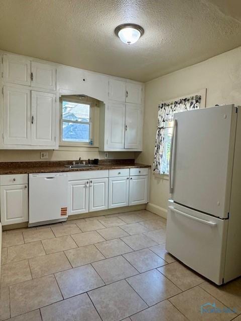 2840 Scottwood Ave, Toledo, OH 43610 - kitchen featuring white appliances, a textured ceiling, white cabinetry, plenty of natural light, and dark countertops