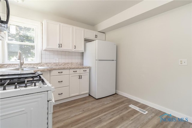926 Searles Rd, Toledo, OH 43607 - kitchen featuring white appliances, white cabinets, light wood-style floors, light countertops, and backsplash