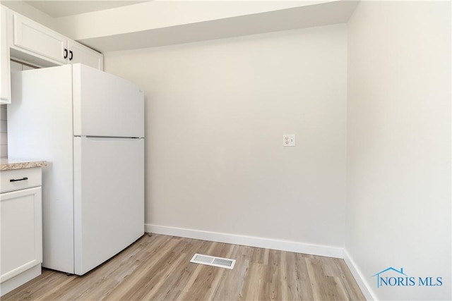 926 Searles Rd, Toledo, OH 43607 - kitchen featuring freestanding refrigerator, white cabinets, and light wood finished floors