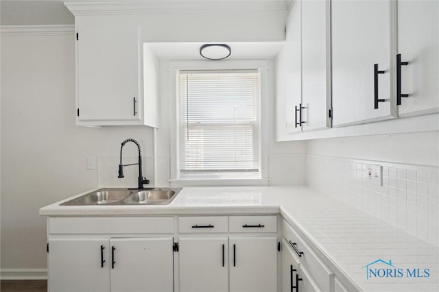 3627 Burton Ave, Toledo, OH 43612 - kitchen with white cabinets, light countertops, ornamental molding, and backsplash