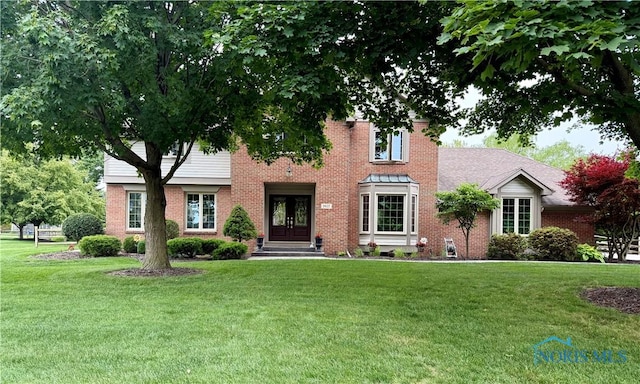 9627 Sheffield Rd, Perrysburg, OH 43551 - view of front facade with french doors, brick siding, and a front lawn