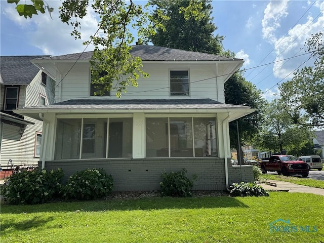 331 Buckeye St, Toledo, OH 43611 - view of front of home featuring a sunroom, brick siding, a front yard, and a shingled roof