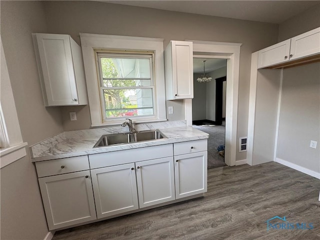 331 Buckeye St, Toledo, OH 43611 - kitchen with a chandelier, dark wood-style floors, white cabinets, and light stone counters