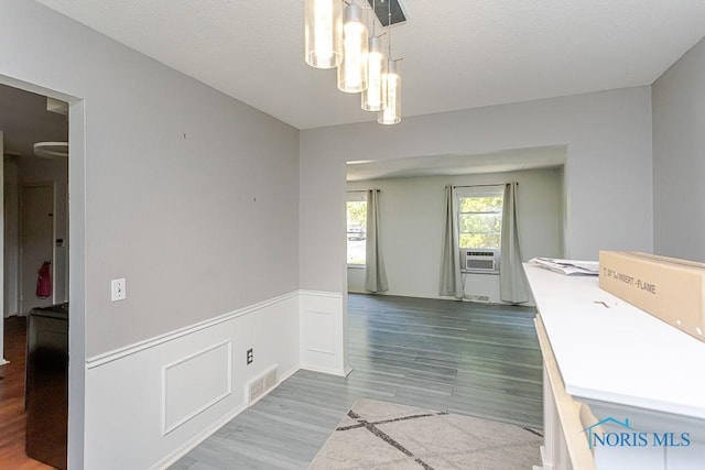 1948 W Terrace View St, Toledo, OH 43607 - unfurnished dining area featuring a wainscoted wall, wood finished floors, cooling unit, and a chandelier